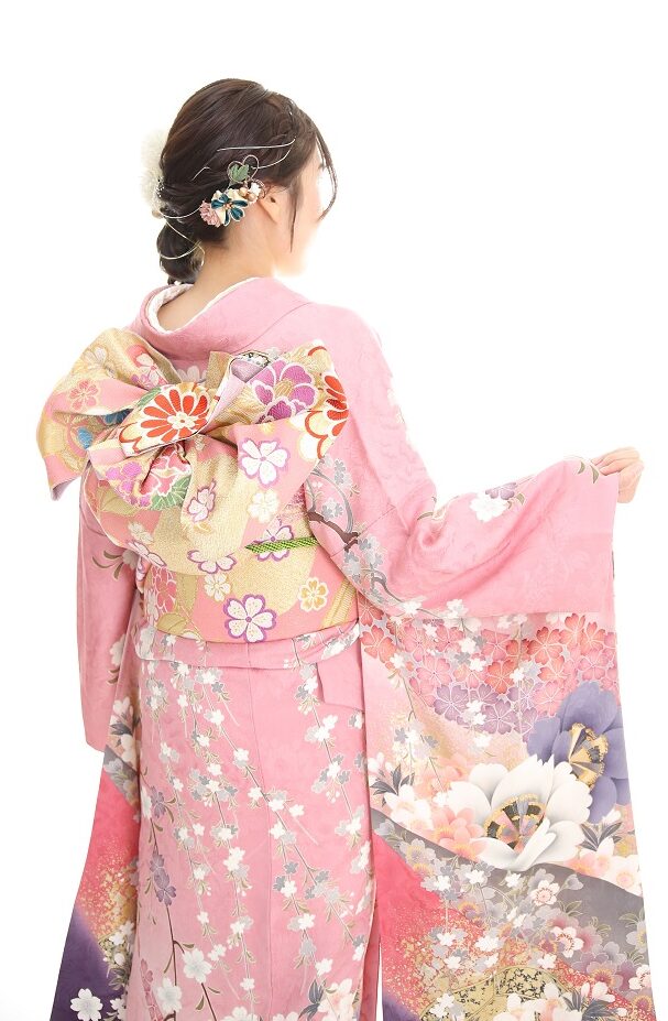 枝垂桜柄のピンクの振袖を着た女性の後ろ姿